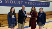 Mark Kasperczyk, board member of the Franciscan Heritage Foundation, presents a check to Mount Mercy Head of School Michele Melligan.
