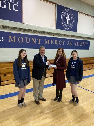 Mark Kasperczyk, board member of the Franciscan Heritage Foundation, presents a check to Mount Mercy Head of School Michele Melligan.